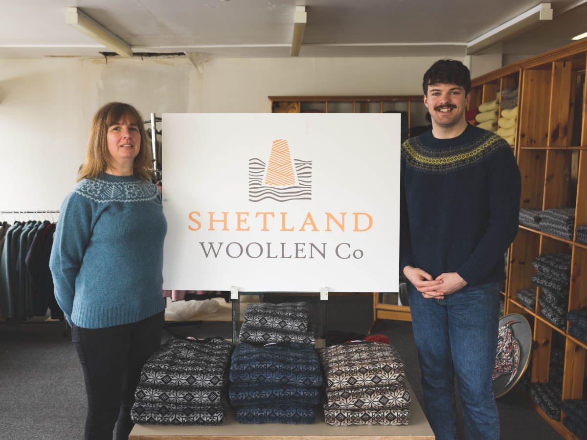 two staff stand beside a white board