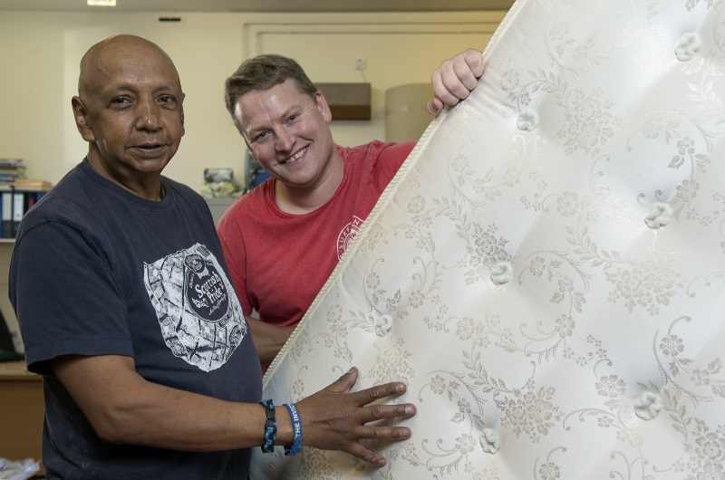 two people holding a mattress in Blindcraft workshop