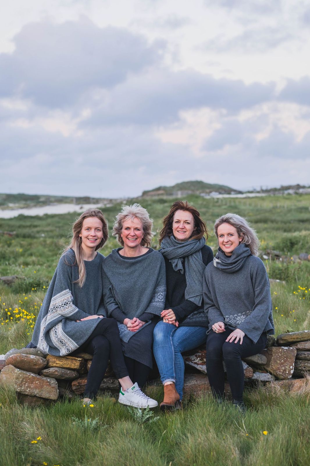Four women from famile business Hume Sweet Hume modelling knitwear in Orkney countryside