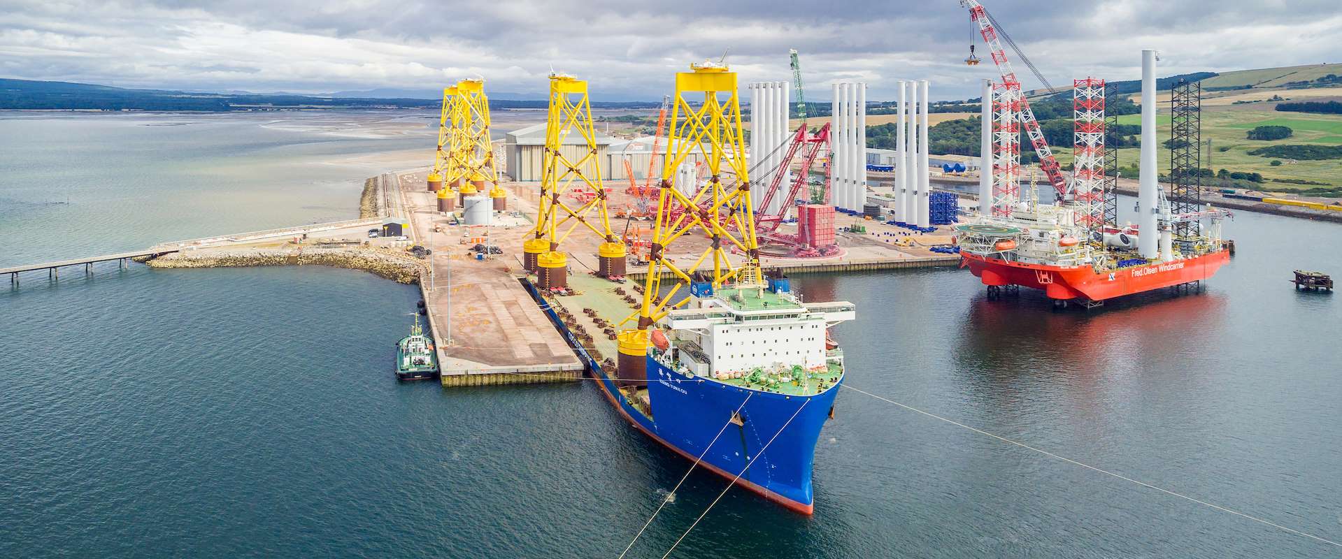 Port of Nigg with large yellow platforms for offshore wind farm